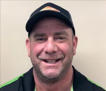 smiling male in a black servpro hat