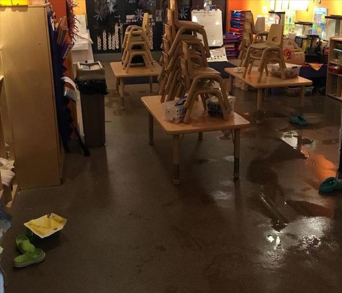 Preschool classroom with stacked chairs on desks and water saturating floors