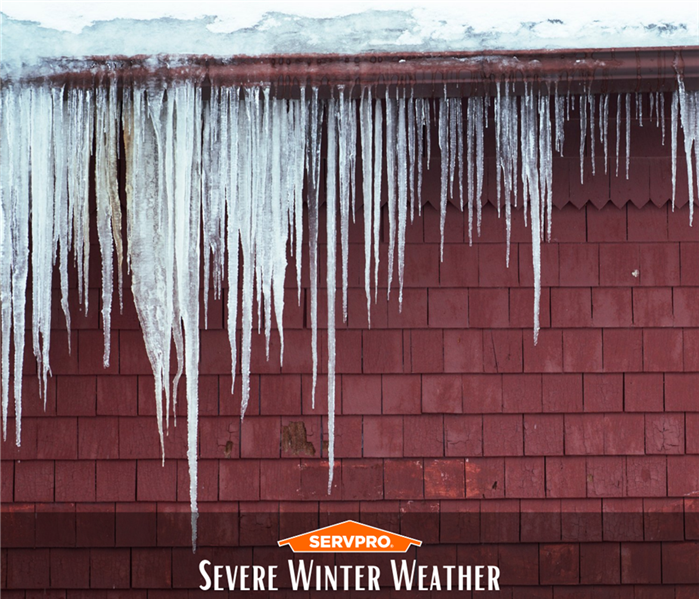 Icicles hanging off roof with SERVPRO logo and text that reads “Severe Winter Weather”