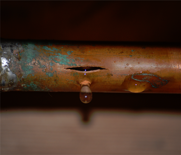 a broken copper pipe leaking water