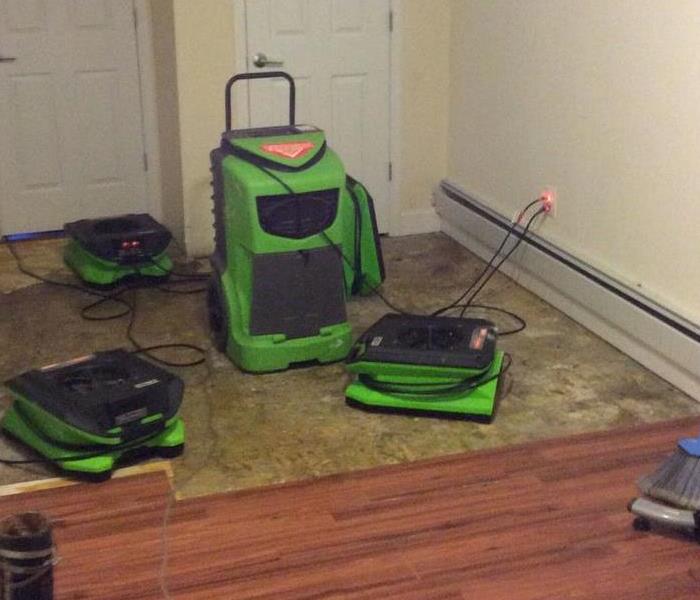 A living room with SERVPRO equipment on the floor. 